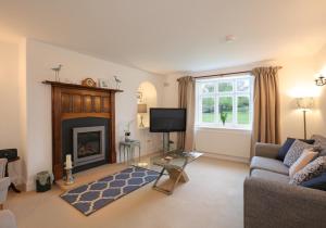a living room with a couch and a fireplace at Primrose Cottage in Gullane