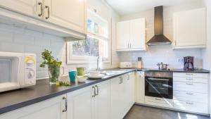 una cucina con mobili bianchi e un forno a microonde di Villa Care 1 - Llafranc a Llafranc
