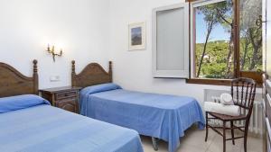 una camera da letto con due letti e una finestra di Villa Care 1 - Llafranc a Llafranc Altre 22 foto