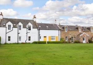 a large white house with a green yard at Primrose Cottage in Gullane
