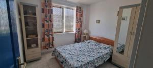 a small bedroom with a bed and a window at CENTRAL APARTAMENT La malul marii 3 camere & Living in Mangalia