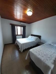 um quarto com 2 camas e um tecto de madeira em AparWil em Encarnación