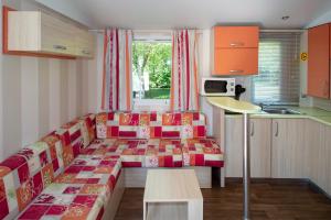 a small room with a couch and a table at Camping du Bournat in Le Bugue
