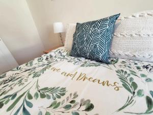 a bed with a comforter that reads are and dreams at Brodie's Hideaway: Stylish two-bed Amble apartment in Amble