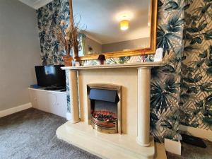 a fireplace in a living room with a mirror at Brodie's Hideaway: Stylish two-bed Amble apartment in Amble