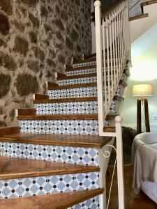 una escalera en una casa con una pared de piedra en La Fragua, en Lanzahita