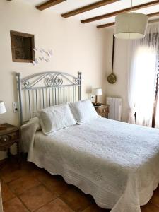 - une chambre avec un lit et une couette blanche dans l'établissement La Fragua, à Lanzahita