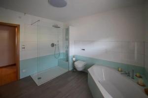 a bathroom with a shower and a tub and a toilet at Ferienwohnung Am Waldrand in Bad Driburg +12 photos