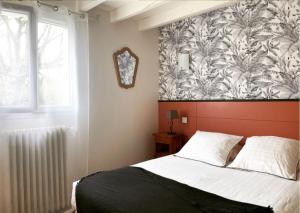 1 dormitorio con 1 cama y un mural en la pared en Gite Botiga, en Saint-Jean-le-Vieux