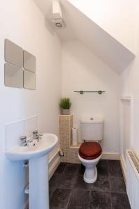 a bathroom with a toilet and a sink at Modern & Spacious Cottage & Private Parking & Leisure in Askern