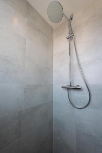 a shower with a shower head in a bathroom at Holiday Home 't Hout in Westkapelle