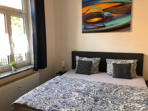 ein Schlafzimmer mit einem Bett und einem Wandgemälde in der Unterkunft City Quartier Jena in Jena