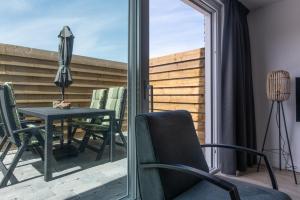 a patio with a table and chairs and an umbrella at Holiday Home 't Hout in Westkapelle