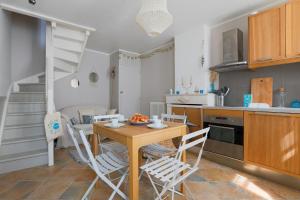 een keuken en eetkamer met een tafel en stoelen bij Maison de village Casserone pour 4 personnes in Ars-en-Ré