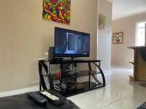 sala de estar con TV y 2 mandos a distancia en Kingstons Finest - Centrally Elegant, en Kingston