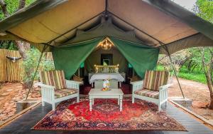 a tent with two chairs and a table in it at Khaya Ndlovu Safari Manor in Hoedspruit +81 photos