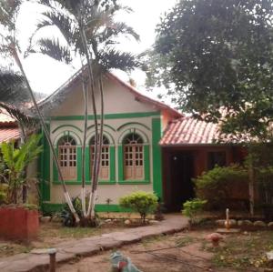 una casa verde y blanca con en Pousada Flor de Cipó, en Serra do Cipo