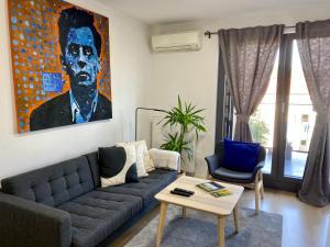 a living room with a couch and a painting on the wall at OnPoint in Zagreb