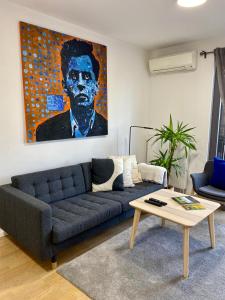 a living room with a blue couch and a painting at OnPoint in Zagreb