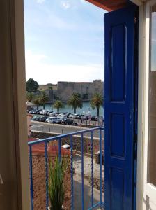 a blue door to a balcony with a view of a beach at 6COMA5 Appartement proche centre ville et plage in Collioure