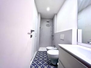 ein weißes Bad mit einem WC und einem Waschbecken in der Unterkunft Casa San Giusto in Lucca