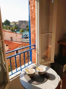 a table with a view of a balcony at 6COMA5 Appartement proche centre ville et plage in Collioure