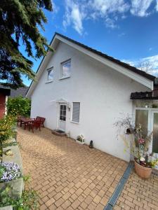 een wit huis met een patio en een kat buiten bij Ferienwohnung Pupavac in Bad Frankenhausen