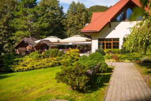 un banco en un jardín junto a una casa en POŁONINY Resort, en Bukowiec