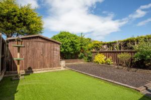 ogród z drewnianą szopą i zieloną trawą w obiekcie Curlew - 3 Bedrooms Wi-Fi, Parking, Contractors w mieście Thornton