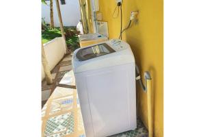 a washing machine sitting next to a yellow wall at Vila Pitangueira - Apto Laranja - No Centro de Serra Grande com Piscina, Jacuzzi, Internet Veloz in Serra Grande