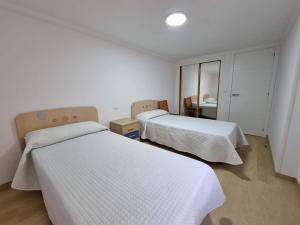 sypialnia z dwoma łóżkami i lustrem w obiekcie Terrazas del Cantábrico w mieście Foz
