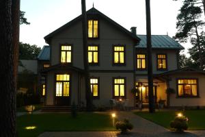 a large black house with its lights on at Apartments Livia in Jūrmala