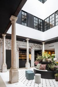 un edificio con columnas y flores en un patio en TOC Hostel Malaga en Málaga