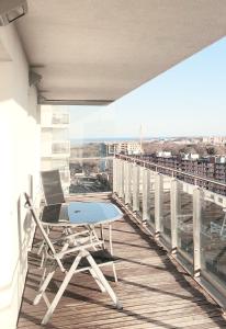 una mesa y sillas en el balcón de un edificio en SAN APARTMENT 16th floor, en Gdansk