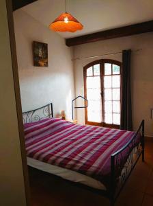 - une chambre avec un lit et une couverture rayée dans l'établissement 6COMA6 Appartement avec terrasse vue mer, à Collioure