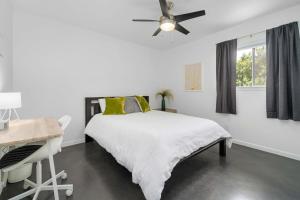 a bedroom with a bed and a desk and a ceiling fan at The Avocado Door - A Mid-Century Modern Gem ~ Near SoCo ~ Fenced yard ~ Corner lot in Austin