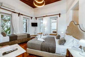 a bedroom with two beds and a desk and windows at Bozzali Deluxe in Chania