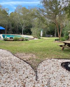 a park with a picnic table and a pool at Cozy RV Experience w/POOL+SPA Near Lake Conroe in Willis