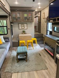 een woonkamer van een camper met een bank en een tafel bij Cozy RV Experience w/POOL+SPA Near Lake Conroe in Willis