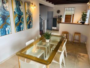 a dining room with a glass table and white chairs at VILLA CORNELIE in Cayenne