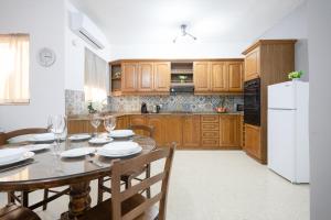 a kitchen with a table and a white refrigerator at Marsalforn Apartment in Marsalforn