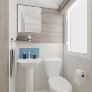 a white bathroom with a toilet and a sink at The Dram Van - Beautiful, luxury static caravan in Aberlour