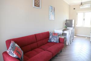 sala de estar con sofá rojo y mesa en Tea Residence, Gjiri i Lalzit Apartments en Durrës