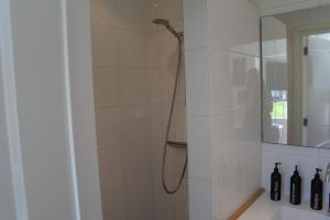 a shower with a shower head in a bathroom at De Parel B&B in Breezand