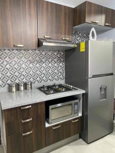 a kitchen with a stove and a refrigerator at Centro histórico Downtown Depto completo alberca climatizada AC parking free seguridad 24 hras in Guadalajara