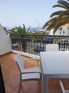 balkon ze stołem i krzesłami oraz oceanem w obiekcie Carlito's home w Aronie