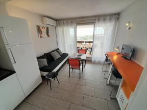 ein Wohnzimmer mit einem Sofa und einem Tisch in der Unterkunft Appartement Village Naturiste Tornado in Cap d'Agde