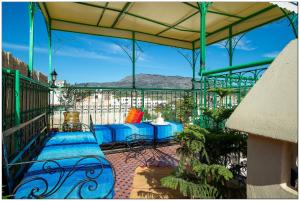 a patio with a bench and a table on a balcony at Riad Fés blida in Fez