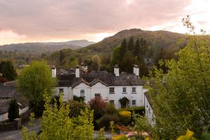 a house in a village with mountains in the background at 5 Lowfield, Ambleside in Ambleside