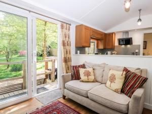 a living room with a couch and a large window at Orchard Lodge in Haywards Heath